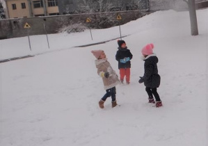 Przedszkolaki bawią się na śniegu